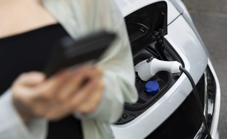 woman-using-her-smartphone-while-electric-car-is-charging woman-using-her-smartphone-while-electric-car-is-charging