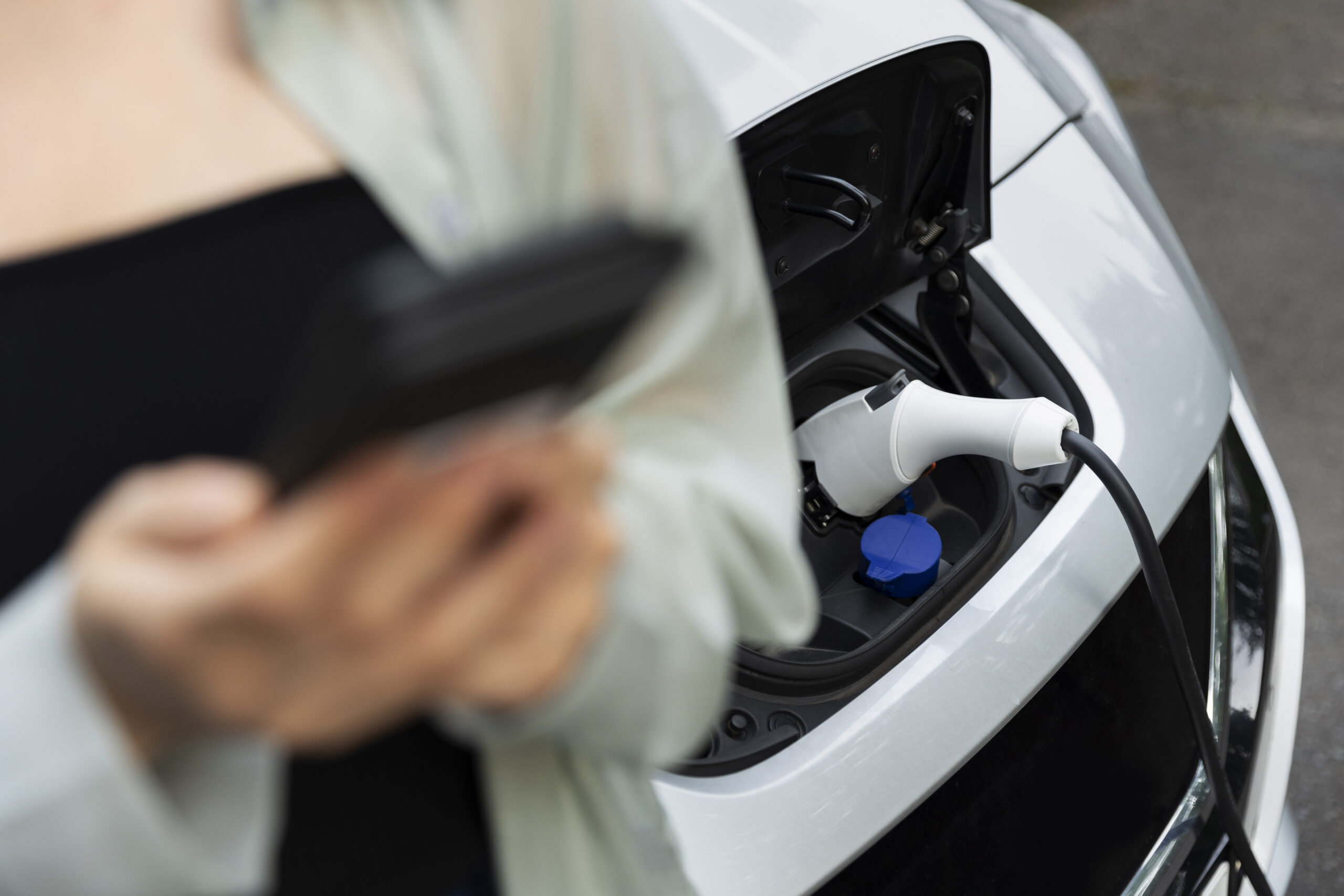 woman-using-her-smartphone-while-electric-car-is-charging woman-using-her-smartphone-while-electric-car-is-charging